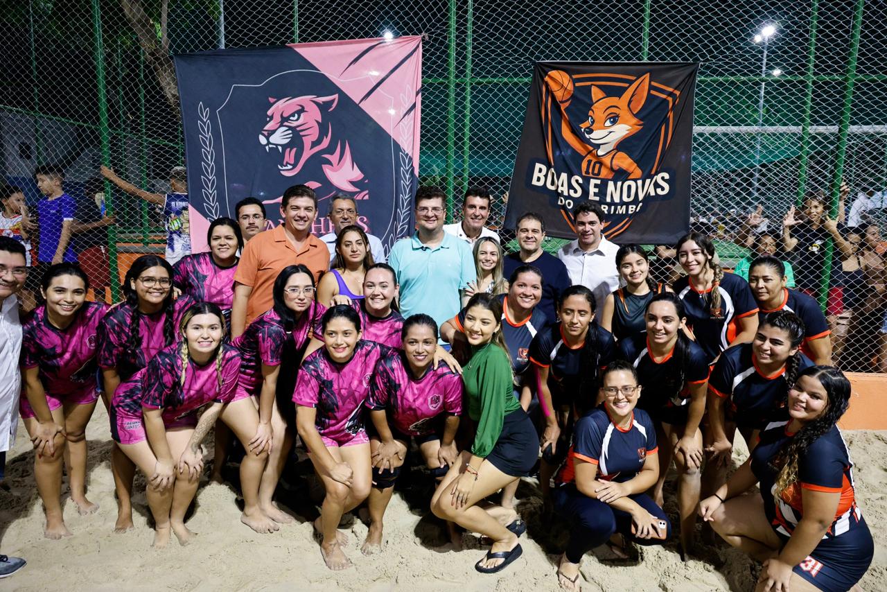 Um grande grupo de esportistas da comunidade posam para foto em frente a quadra da praça
